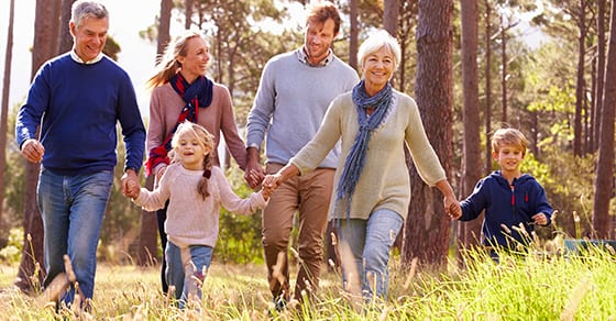 Happy family walking through woods