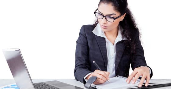 Woman looking at laptop while working on finances