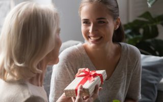 grandmother giving her granddaughter a wrapped gift